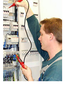 Mitarbeiter beim Pr&uuml;fen eines Verteilerschranks.